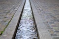 Water stream in formalised rill in pavement