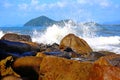 Water in strong waves lapping on the rocks. Coast of Bertioga, Brazil