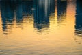 Water surface cityscape reflection with golden sunset