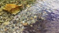 Water surface and colourful stones. Pure clean river water is running. ÃÂ¡louds are reflected in the water.