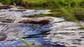 Water surface and colourful stones. Pure clean river water is running. ÃÂ¡louds are reflected in the water.