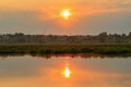 Water surface of river at sunset with reflection of orange sun. River landscape