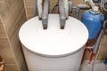 Water tank for a modern gas boiler in the home boiler room lined with ceramic tiles.