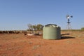 Water tank and windmill in Australian outback with cattle and stock