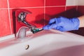 Water tap in detail with limescale close up soiled bathroom Calcified faucet. gloves for washing