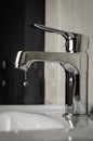 Water tap, faucet dripping in bathroom. Close up, vertical. Royalty Free Stock Photo