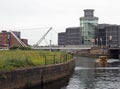 A water taxi near knights bridge crossing the river aire and canal in leeds with apartments and the royal armouries museum on the