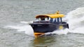 Water taxi speeding on a river in Port of Rotterdam, The Netherlands