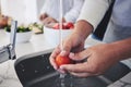 Water, tomato and hands cleaning vegetable for cooking in a kitchen basin or sink in a home for hygiene as a chef. Salad Royalty Free Stock Photo