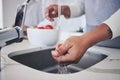 Water, tomato and person hands cleaning vegetable for cooking in a kitchen basin or sink in a home for hygiene. Salad Royalty Free Stock Photo