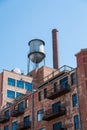 Water Tower on Old Brick Building with Metal Balconies Royalty Free Stock Photo