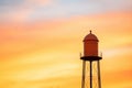 water tower silhouette during orange tinted sunrise Royalty Free Stock Photo
