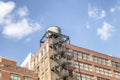 Water towers or rooftop Water Tank on an Apartment Building with Fire Escape stairs in New York. Deposits typical of a rooftop in Royalty Free Stock Photo