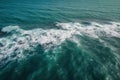 the water is very blue and green with white foamy waves on it\'s surface and a boat in the distance in the distance