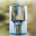 A water vortex with small bubbles spins in a transparent cylinder. Water energy.