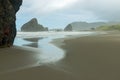 Water washes over the sandy beach between the sea stacks on the Pacific coast at Pistol River State Park, Oregon, USA Royalty Free Stock Photo