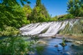 Water waterfall sliding down stone wall in green plant forest