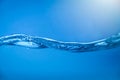 Water waves with air bubbles in clear blue water Royalty Free Stock Photo