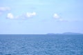 A beautiful seascape in a horizontal line against white fluffy clouds blue sky