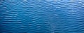 Water Waves Surface as Background. Light ripples in the water. Beautiful abstract banner in blue. Straight lines of waves along Royalty Free Stock Photo