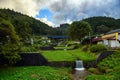 The water weir is surrounded by nature in rural Japan, on a cloudy day in the valley village of Fukushima, a concrete gutter slows Royalty Free Stock Photo