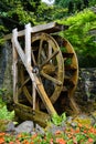 A motion-blurred water wheel with flowers in the foreground Royalty Free Stock Photo