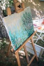 Watercolor drawing on canvas stand placed in garden