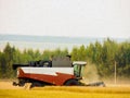 Watercolor drawing: a combine harvester harvests grain on the field