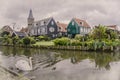 Watercolor effect of photo with view of swan swiming in the canal near traditional wooden fishing houses in Marken, Netherlands.