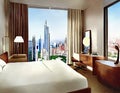 Watercolor of A furnished bedroom with a view of the city through the