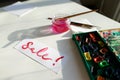 Watercolor inscription Sale on white sheet of paper, on table in