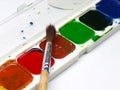 Watercolor paints with a brush on a white background. Royalty Free Stock Photo