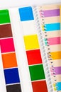 Watercolor paints, paint brushes, color pencils on desk