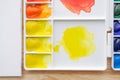 Watercolor paints in white watercolor palette. Bright multicolored aquarelle paints in box