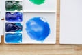 Watercolor paints in white watercolor palette. Bright multicolored aquarelle paints in box