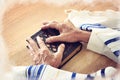 Watercolor style and abstract image of Old Jewish man hands holding a Prayer book. Jewish traditional symbols.