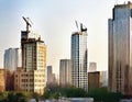 Watercolor of A tower crane constructs a tall building beside a tiny