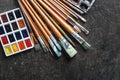 Watercolors with paint brushes on grey background Royalty Free Stock Photo