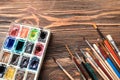 Watercolors with paint brushes on wooden table Royalty Free Stock Photo