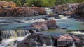 Colorful Waterfall rocky quarry surrounded by green tries and painted rocks