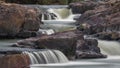 Colorful Waterfall rocky quarry surrounded by green tries and painted rocks