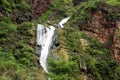 Waterfall in Ayn Khor and Lush green landscape, trees and foggy mountains at tourist resort, Salalah, Oman