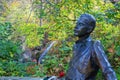 Waterfall in beautiful autumn castle park of Lillafured. Blurred monument to famous Hungarian poet Jozsef Attila in foreground Royalty Free Stock Photo