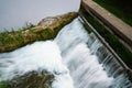 Waterfall behind the dam on the river in city. The flow of water Royalty Free Stock Photo