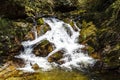 Waterfall and big green rocks in the woods next to Burning Lake in Central Bhutan Royalty Free Stock Photo