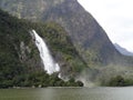 Waterfall with big river and forest at Milford sound, New Zealand Royalty Free Stock Photo