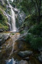 Waterfall caresses the granite rock before falling into a pool and forming a stream Royalty Free Stock Photo