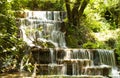 Waterfall. The cascade of waterfalls falls down between green trees