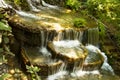 Waterfall. The cascade of waterfalls falls down between green trees