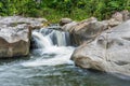 Waterfall cascades flowing over flat rocks in forest